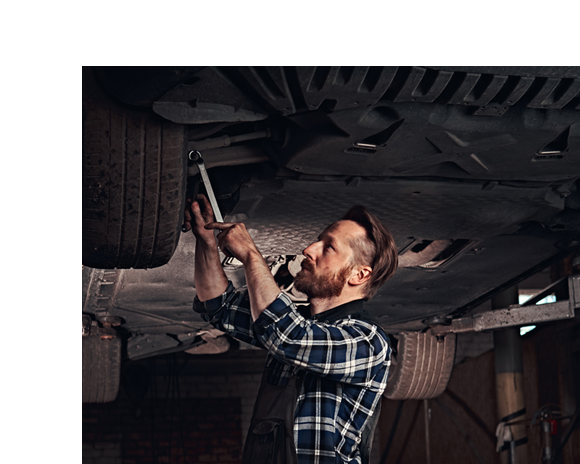 mechanic in blue fixing wheel of vehicle